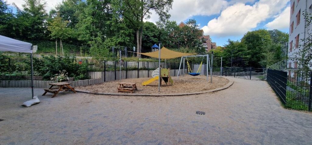 Das Außengelände der AWO Kita Denickestraße mit Schaukel und Rutsche.