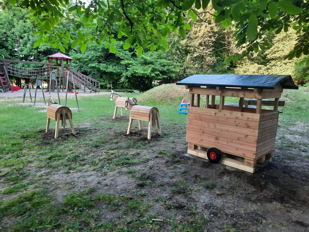 Außengelände mit Klettergerüst und Holzpferden in der Kita Jonni Birckholtz.