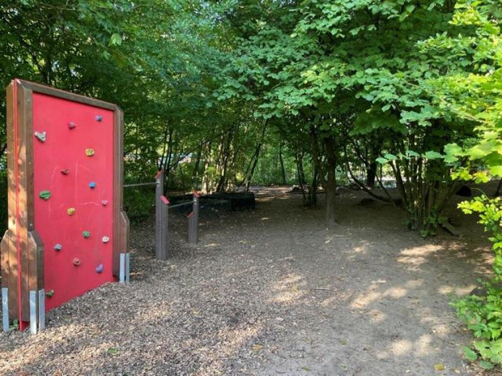 Außenbereich mit Kletterwand und Stangen der Kita Löwenzahn der AWO Hamburg.