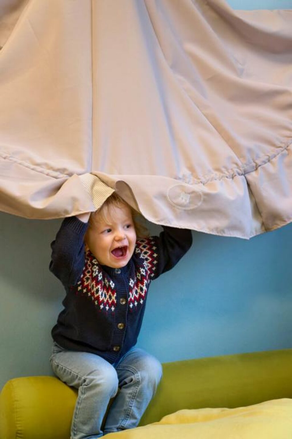 Gruppenraum der AWO Kita Am Tannesnhof, Kind beim Versteckspiel.
