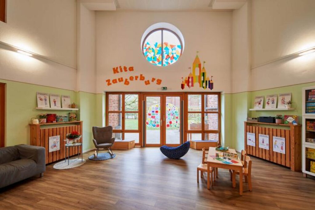 AWO Hamburg in der Kita Zauberburg Gruppenraum mit Sofa und Kindertisch.