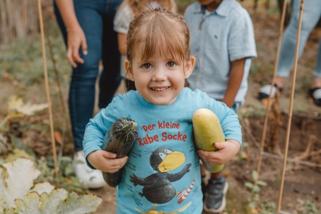 Kindertagesstätte Zauberburg der AWO Hamburg Kind mit Zucchini.